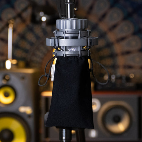 AKG 414 mic upside down on a stand with medium size synthetic dust free medium cover